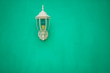 Emerald vintage lamp on emerald wall.