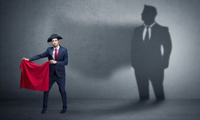 Businessman standing with red cloth on his hand and his shadow on the background
