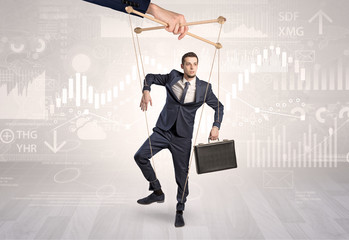 Puppet businessman controlled by another hand with financial concept
