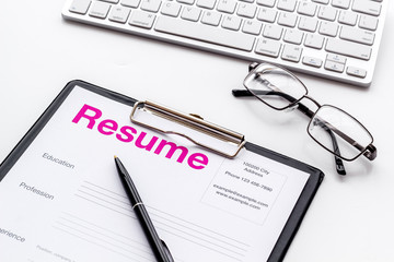 Create CV concept with pen, glasses, keyboard on white desk top view