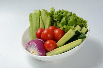 fresh vegetables on a plate isolated on white