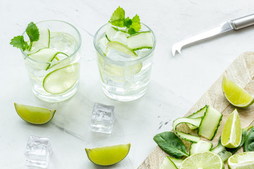 cold water with ice, spinach, cucumber and lime juice for summer healthy drink on white background