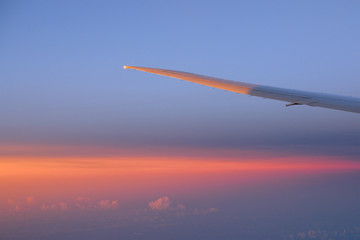 wing aircraft in the sky with clouds at sunset
