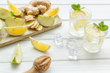 fresh drink with ice, ginger, mint, apple and lemon on white background