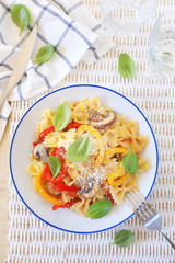 Italian cuisine. Neapolitan pasta. Farfalle with mushrooms and belle pepper and cheese