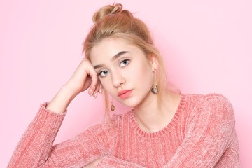 Beautiful young woman with make-up isolated on pink background.