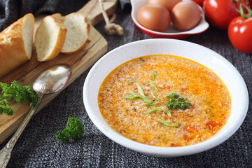 Italian cuisine. Stracciatella tomato soup: parsley, eggs and parmesan cheese