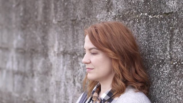 Woman leaning against wall outdoors, Slow motion shot