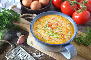 Italian cuisine. Stracciatella tomato soup: parsley, eggs and parmesan cheese