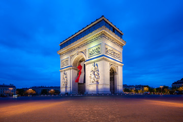 Obraz na płótnie Canvas Paris street at night with the Arc de Triomphe in Paris, France.