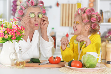 Obraz na płótnie Canvas Senior woman and girl with pink hair curlers on head