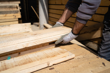 Close up on the worker holding building material planks loading at the warehouse for the construction site