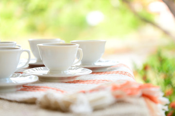 outdoor breakfast, breakfast table with white cups, breakfast in the garden, afternoon tea, white coffee cups, white porcelain coffee cups in nature, rustic breakfast on a summer day