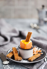 Soft boiled egg with rye toasts for breakfast