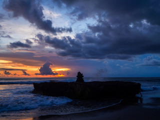 Silhouette of an altar at sunset and colorful clouds in the shape of an altar. Bali.