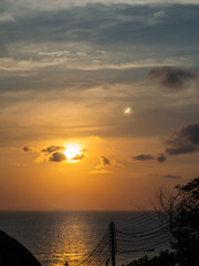 Silhouette of electrical wires against the sun setting in the sea. Ko Phangan.Thailand.