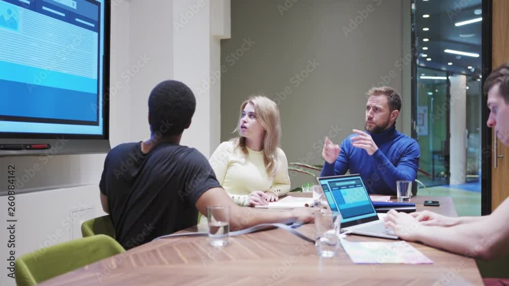 Wall mural tracking shot of diverse business team with experienced manager discussing website templates present