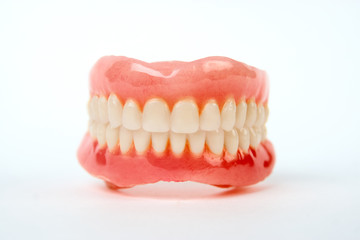 Artificial teeth on a white background with copy space