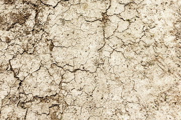 Dry earth after drought pattern. Cracks on sandy ground texture.