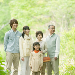 新緑の中で微笑む3世代家族