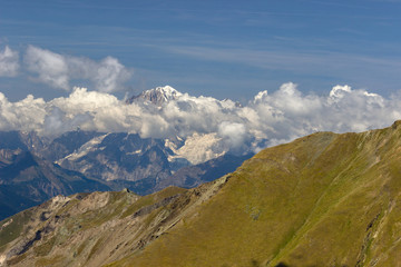 Hiking in Aosta valley, Italy. View of Mont Blanc Massif with cloudy sky. Telephoto from Mount Creya (Cogne valley).