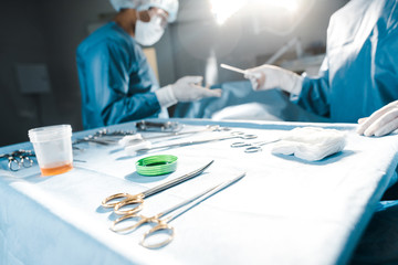 selective focus of nurse giving medical equipment to surgeon in operating room