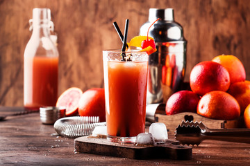 Summer refreshing low alcoholic cocktail with vodka, orange juice, bloody orange and ice cubes. Wooden table. Selective focus. Copy space