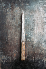 Old rustic handmade knife on the rustic background. Selective focus. Shallow depth of field. 