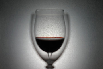 glass of red wine through another glass