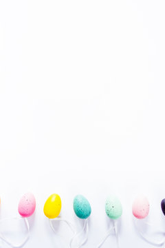 Colorful small eggs arranged in a circle egg shaped on a white background, holiday easter concept