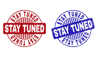 Grunge STAY TUNED round stamp seals isolated on a white background. Round seals with grunge texture in red and blue colors. Vector rubber imprint of STAY TUNED caption inside circle form with stripes.