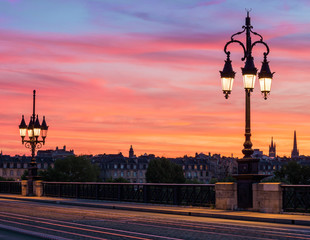 Bordeaux Stone Bridge with beautiful streetlights and amazing sunset sky over the Bordeaux city, France.