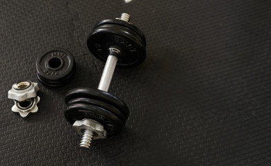Naklejka na ściany i meble Top view of Iron dumbbells or weights on black floor with copy space for text. Flat lay composition. Health care concept.