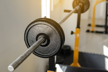 Fototapeta premium Side view of barbell on the rack in fitness gym. Weight Training Equipment. Health care concept.