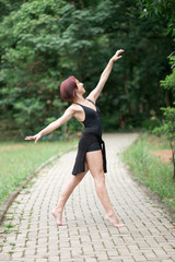 Obraz premium Happy redhead smiling girl dancing in a green park on Brazil in a summer day