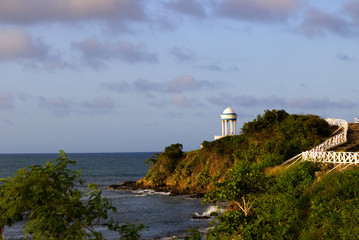 Fototapeta na wymiar White rotunda on a cliff by the ocean at sunset