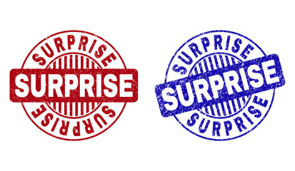 Grunge SURPRISE round stamp seals isolated on a white background. Round seals with grunge texture in red and blue colors. Vector rubber watermark of SURPRISE tag inside circle form with stripes.