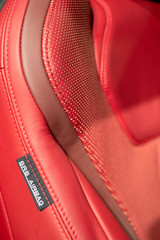 Part of red sport seat in modern sport car with airbag texture label.