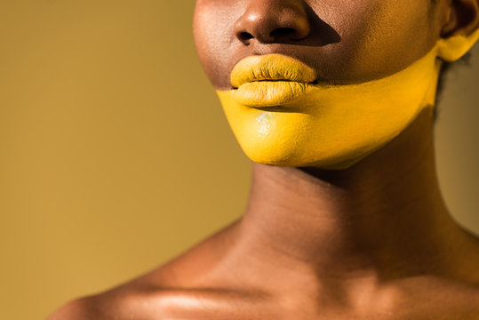 Cropped view of african american woman with yellow body art on brown