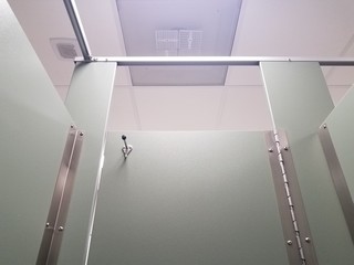 closed bathroom or restroom stall door with coat rack or hook