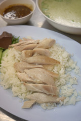 Hainanese chicken rice or steam chicken rice with sauce on dark background.Khao Man Gai Recipe