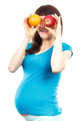 Pregnant woman holding fruits at her eyes, healthy food during pregnancy