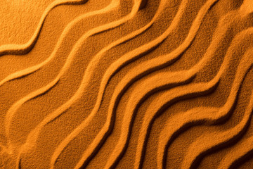 top view of sandy background with smooth waves and orange color filter
