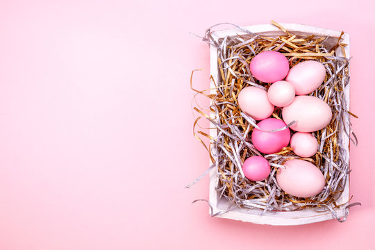 Eggs in a white tray. Creative Easter concept. Modern solid pink background. Horizontal