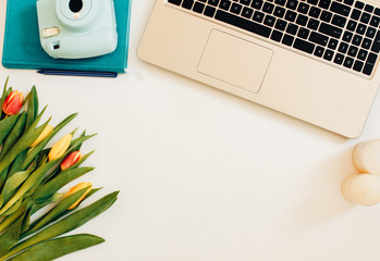 Stylish flat lay home office desk workspace with laptopTop view lifestyle blog. Flat lay, Bunch of spring tulip flower.A bouquet of spring flowers with  laptop. Spring Tulips Background. Mothers day.