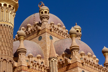 Old eastern architecture on a background of blue sky close-up. Beautiful brickwork in oriental culture. Architecture of the East with a variety of monograms, masonry and decorations.