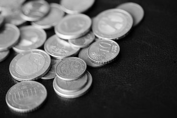 Euro coins scattered on a dark background close up. Black and white