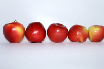 Five red apples in a row horizontally on a white background