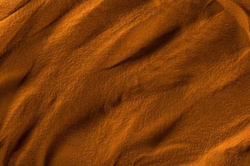 top view of textured beach sand with waves and orange color filter