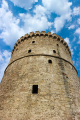 Fototapeta na wymiar White tower in Thessaloniki, Greece against blue sky with clouds closeup